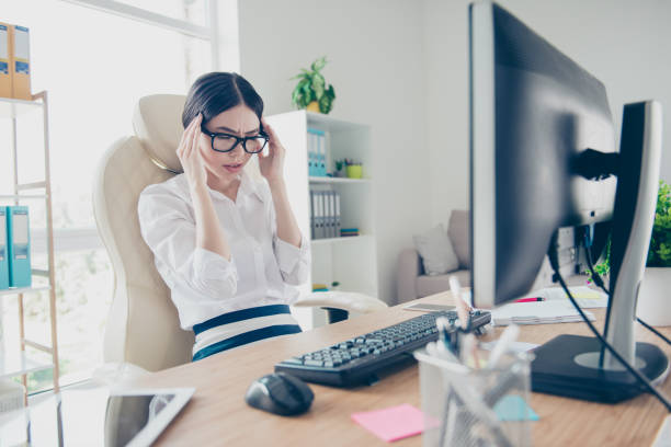 istock Overworked stressed young asian business lady is having headache and thinking how to end project. She is wearing strict shirt and glasses 937233948