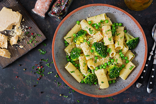 Pasta rigatoni with broccoli and green peas. Vegan menu. Dietary food. Flat lay. Top view.