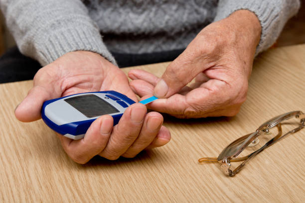 istock Senior man with glucometer checking blood sugar level at home 937238496