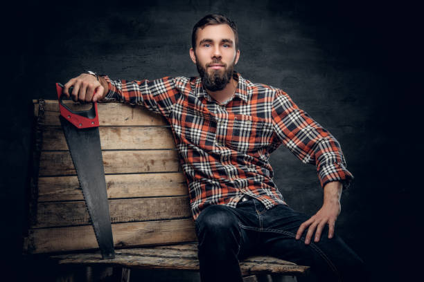 istock Bearded carpenter male holds handsaw. 937239664
