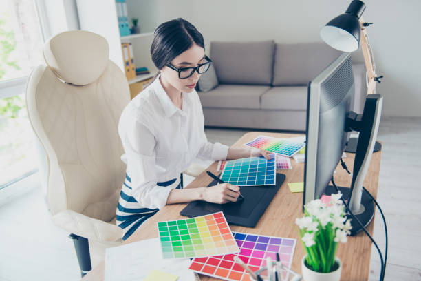 istock Busy young asian graphic designer is drawing something on graphic tablet at the office, focused. She is a successful self employed artist 937244914