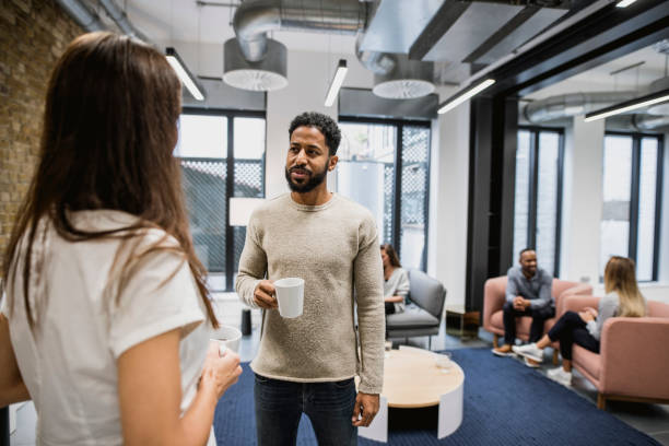 istock Coworkers drinking coffee and talking in the board room 937245238