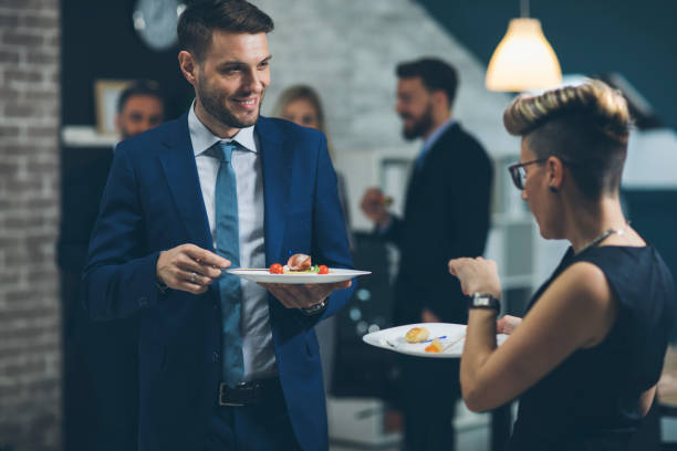 Business Conference And Event Business people eating and talking at buffet in business lounge. office parties stock pictures, royalty-free photos & images
