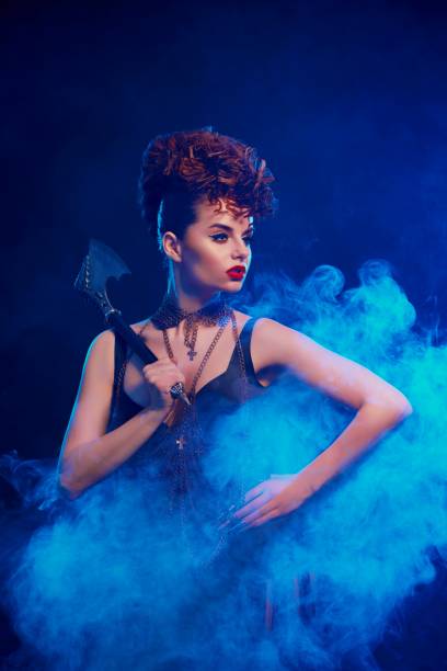 istock Dangerous girl with sharp axe stands in smoke cloud. 937248992