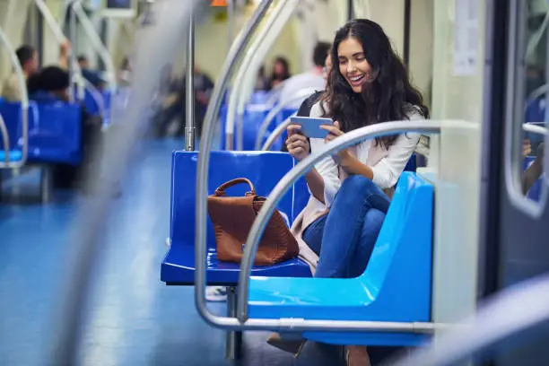 Shot of a young attractive woman using a cellphone while commuting with the train