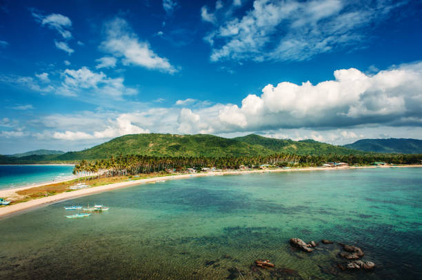 istock Tropical country, beach with palm trees, blue sky with clouds. Isthmus between two seas. Philippines, Palawan, Napcan beach 937253566