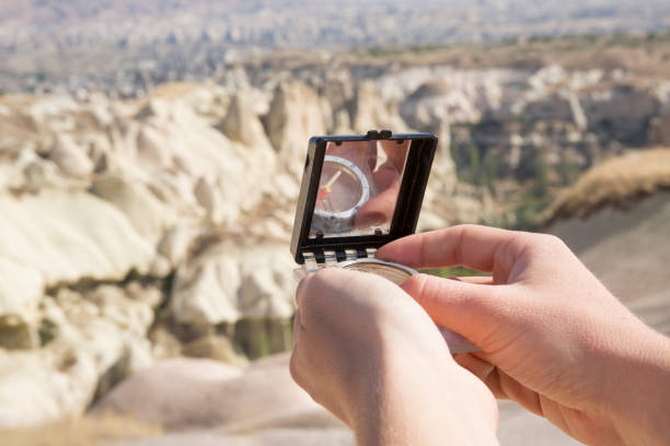 istock Detail of hands using compass in sandstone hills. 937254412