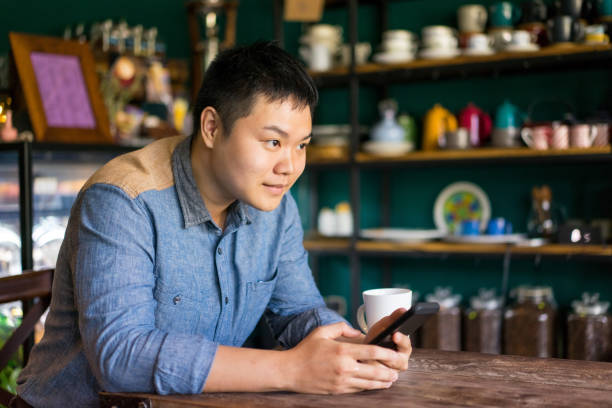 istock Pensive young Asian man having coffee break 937256784