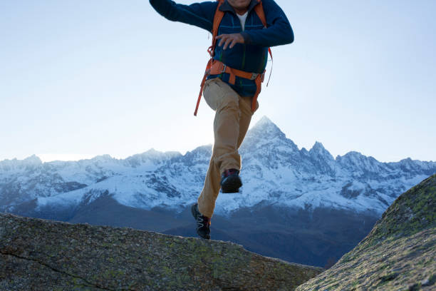 istock Hiker jumps onto rock slab. 937257574