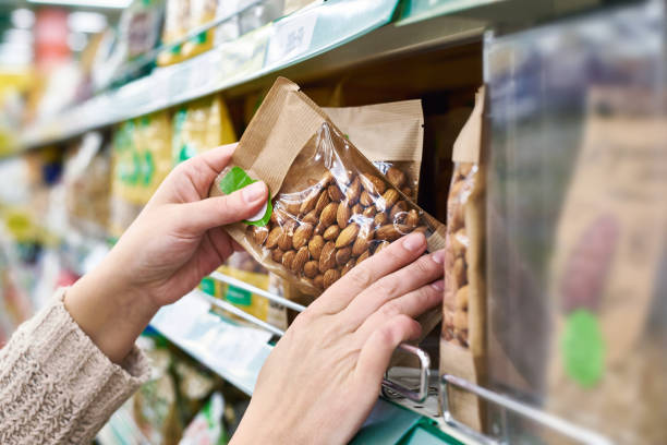 istock Hands with packaging of almond nuts in store 937257712