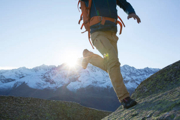 istock Hiker jumps onto rock slab. 937257966