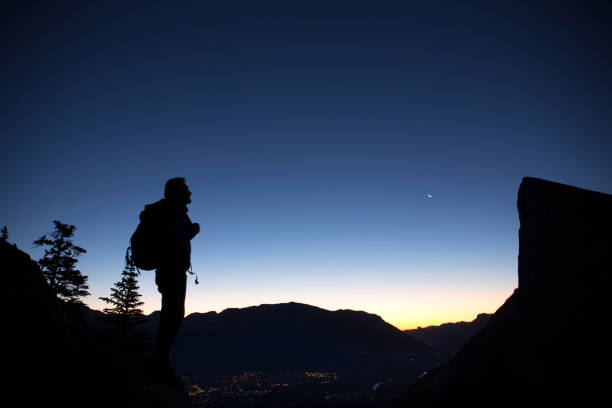 istock Hiker pauses at twilight to look at peak. 937258040