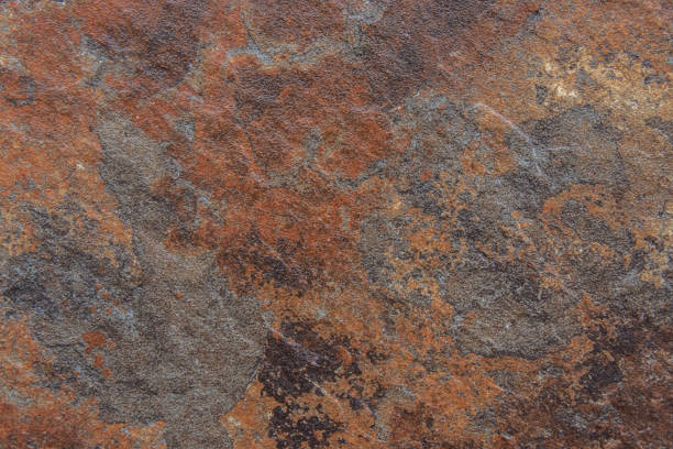 Old Distressed Brown Terracotta Copper Rusty Stone Background with Rough Texture Multicolored Inclusions. Stained Gradient Coarse Grainy Surface. Wallpaper Template