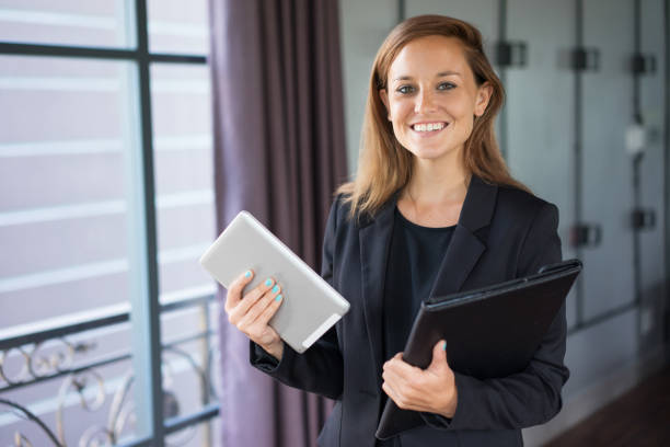 istock Happy Woman with Tablet and Folder at Window 937260712