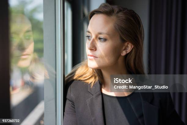 Señora De Negocios Pensativo Mirando A Través De La Ventana Foto de stock y más banco de imágenes de Mujeres