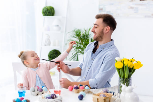 istock Father and daughter having fun while painting eggs for Easter 937270860