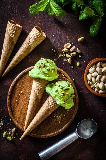istock Pistachio ice cream cones shot on rustic table 937271616
