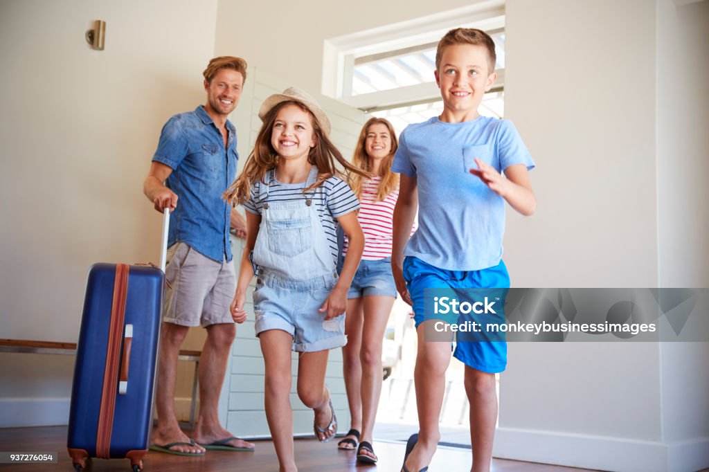 Family Arriving At Summer Vacation Rental Family Stock Photo