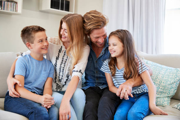 istock Smiling Family Relaxing On Sofa At Home Together 937278608