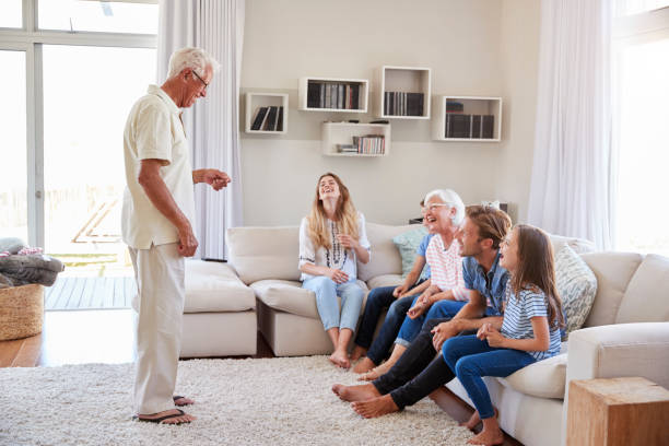 istock Multi Generation Family Sitting On Sofa At Home Playing Charades 937278768