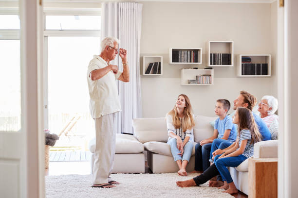 istock Multi Generation Family Sitting On Sofa At Home Playing Charades 937278770
