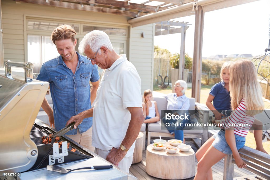 Multi generación familia disfrutando de cocinar barbacoa en casa - Foto de stock de Familia libre de derechos