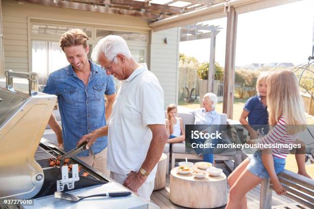 Multi Generación Familia Disfrutando De Cocinar Barbacoa En Casa Foto de stock y más banco de imágenes de Familia