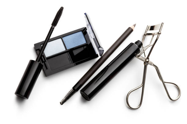 Young women applying mascara in front of the mirror. Preparing for night out.