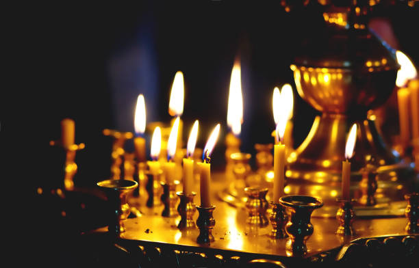 des bougies allumées dans l’église en signe de repentance et de la miséricorde devant dieu - church altar indoors dark photos et images de collection