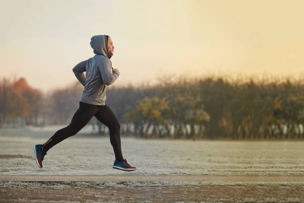 寒い秋の朝の間に公園でランニングする運動青年 - 走る ストックフォトと画像