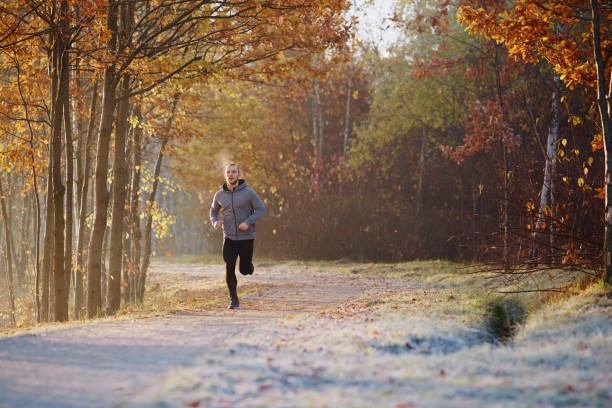 istock Young man running at park during cold autumn morning 937286058