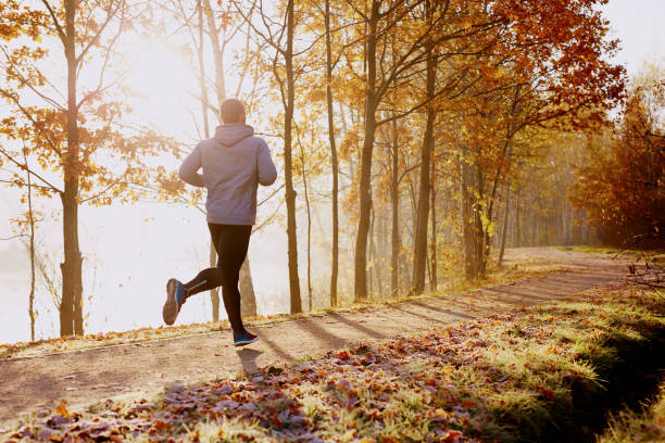 istock Man running in park at autumn morning 937286160