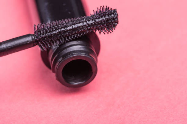 istock Eyelash makeup brush and mascara bottle close up on pink background with copyspace 937286612