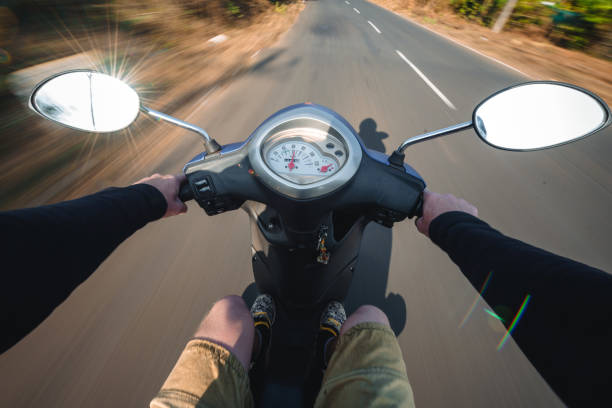 istock Rider driving scooter on an asphalt road. Motion blurred backgro 937291186