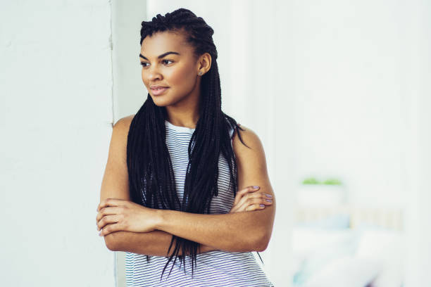 物思いにふける若いアフリカ系アメリカ人の女性は家庭で - braids african descent women pensive ストックフォトと画像