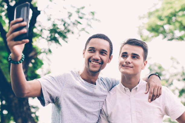 istock Cheerful multiethnic male friends taking selfie 937294652