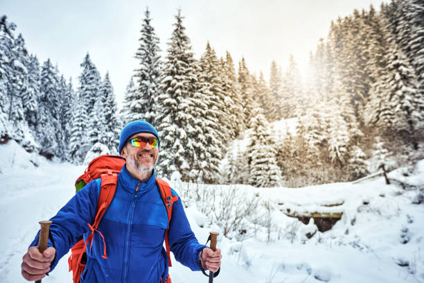 Winter hike guy in the mountains with a backpack and tent.