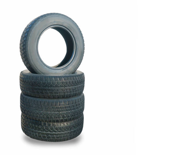 istock Stack of four wheel new black winter tyres for car 937295524