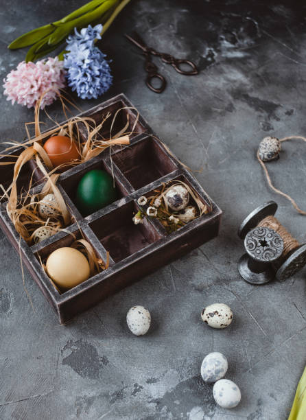 istock Easter celebration template with colored eggs in box and flowers on table 937299414