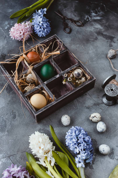 istock Painted chicken and quail eggs in box with hyacinths on slate background 937299498