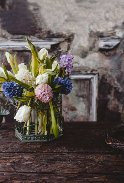 istock Metal vase with spring flowers on wooden table 937299618