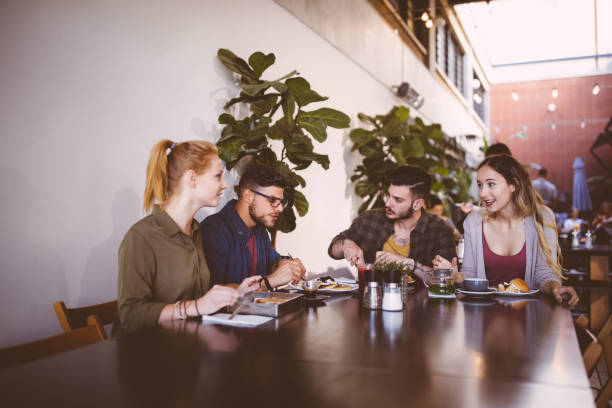 istock Young friends talking and having a meal at urban restaurant 937302040