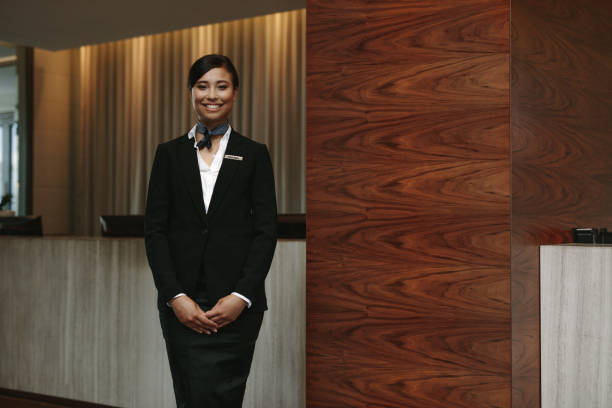 istock Female receptionist standing at hotel front desk 937302368