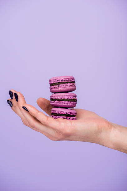 istock Woman holding macarons isolated on violet 937306124