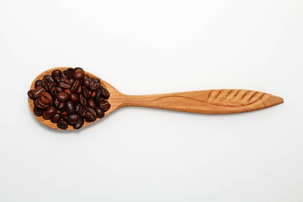 istock Wooden spoon with coffee beans on white background 937306532