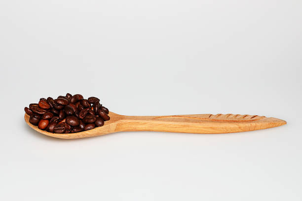istock Wooden spoon with coffee beans on white background 937306542