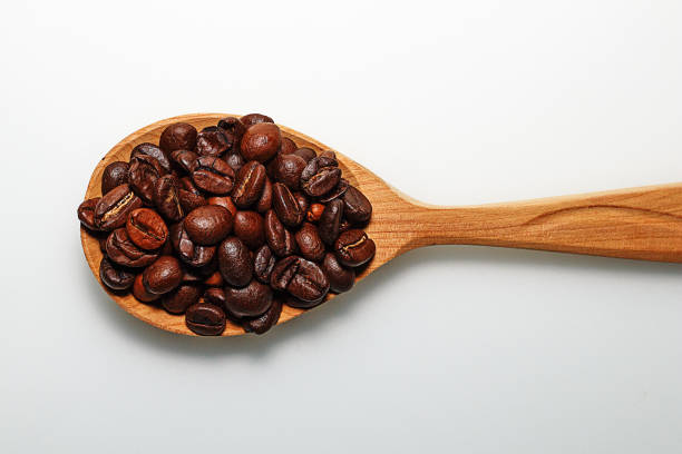 istock Wooden spoon with coffee beans on white background 937306548