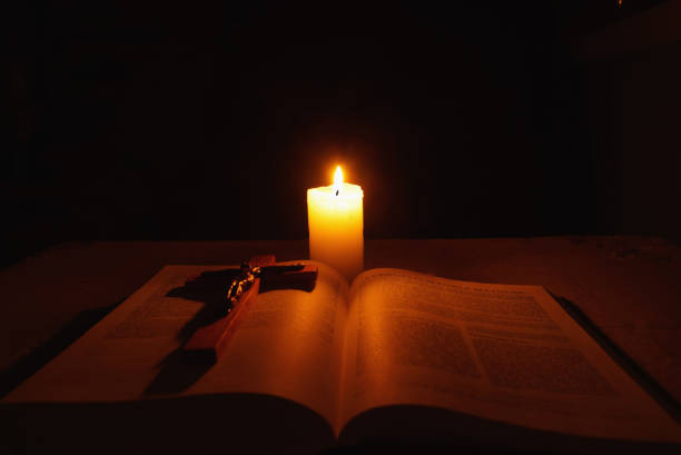 istock Burning candle, bible and crucifix on desk 937311676