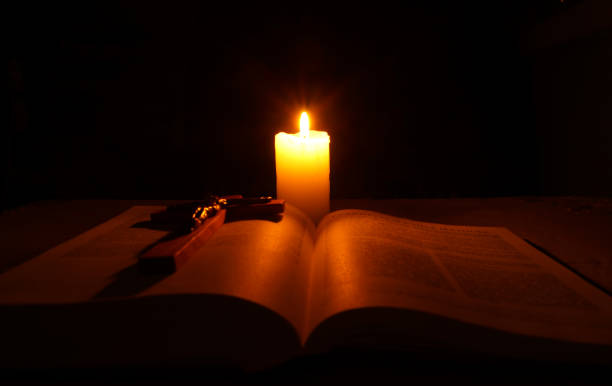istock Burning candle, open Bible and crucifix 937311794