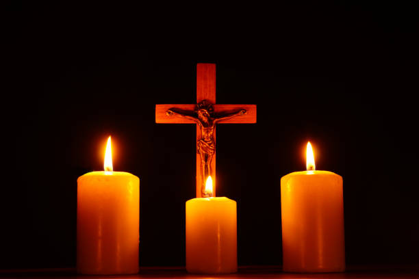 istock Crucifix and three burning candles in the darkness 937311970